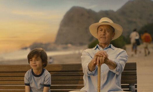 Robert Downey Jr. sitting beside a kid by a beach