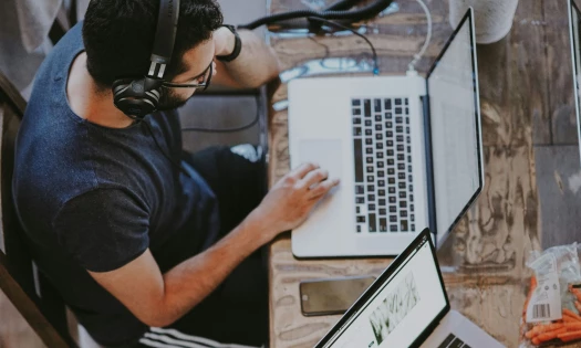 man sitting on chair and looking at laptop