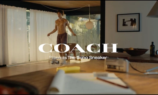 Charles Melton working out in his living room, while wearing the Coach 'Soho' sneaker