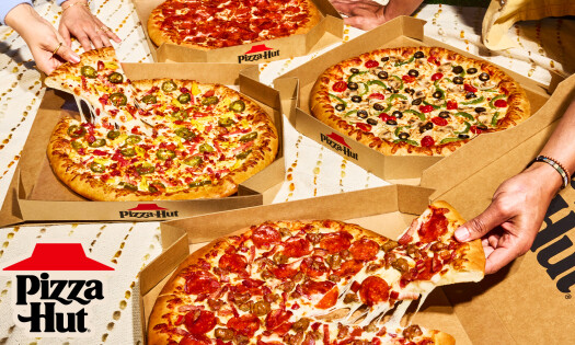 Three people grabbing a slice of Pizza Hut pizza