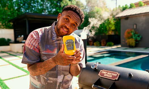 Mustard holding up his new condiment with Heinz