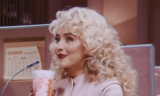 Sabrina drinking from a Dunkin' cup