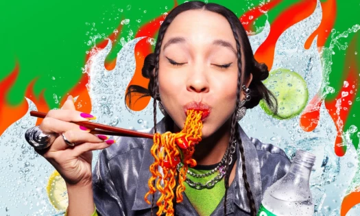 A woman enjoying her spicy noodles alongside Sprite