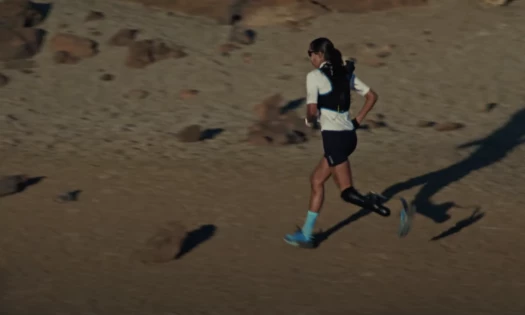 An athlete runs across sandy fields