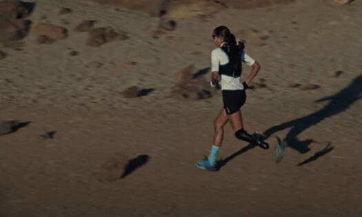 An athlete runs across sandy fields