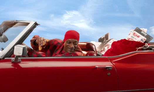 Snoop Dogg on a vehicle with Raising Cane's on the backseat