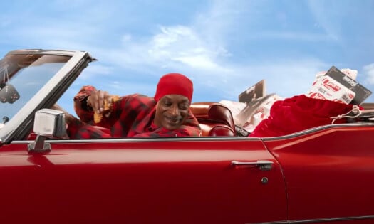 Snoop Dogg on a vehicle with Raising Cane's on the backseat