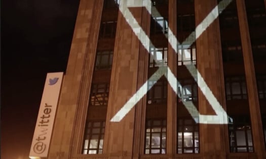 The Twitter building with a big "X" light projected on its walls