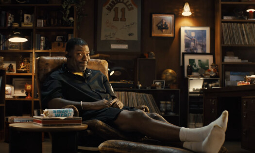 A man sits on his couch beside a Snack Wrap placed on his table
