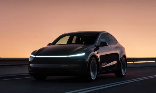 A black Tesla Robotaxi on the road
