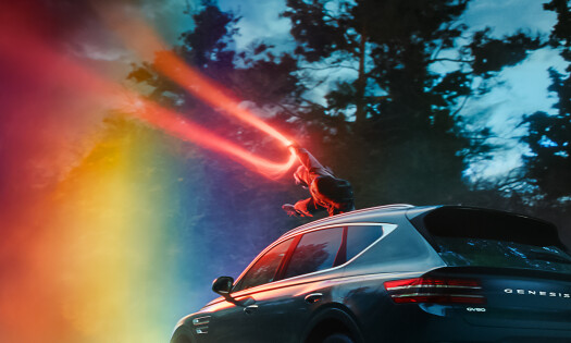 A young girl pulls a streak of light on top of the Genesis GV80