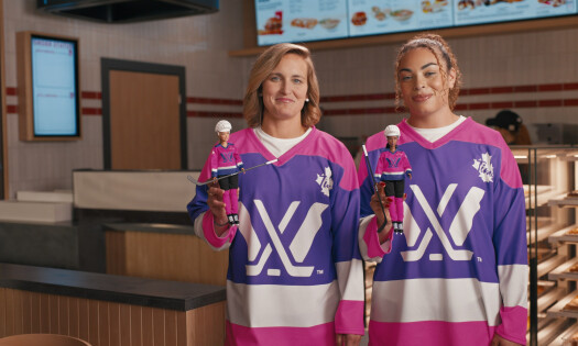 Two athletes pose in their Barbie x Tim Hortons branded jersey and dolls