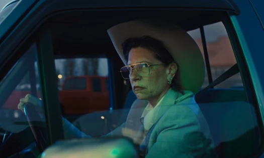 An elderly woman sits on the driver's seat