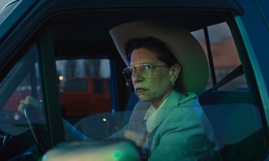 An elderly woman sits on the driver's seat