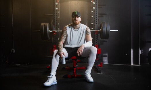 Maxx Crosby in the gym with a can of Monster in hand