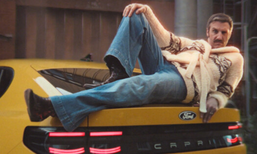 A man lies down on the trunk of the new Ford Capri