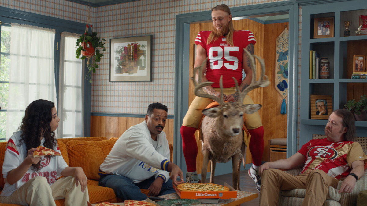 George Kittle riding a deer while other people eat Little Caesars
