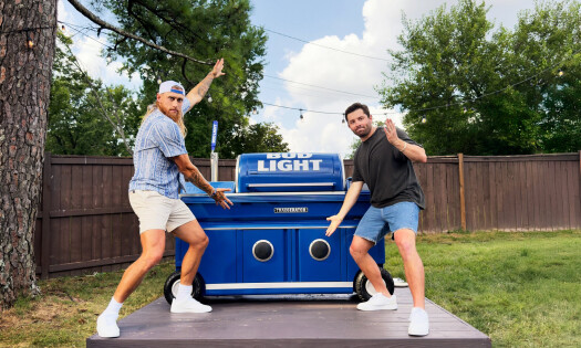 George Kittle and Baker Mayfield in a backyard presenting the 'Traegerator'
