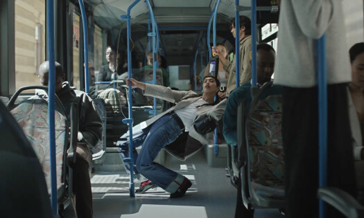 A woman wearing Primark denim pants dances in a bus.
