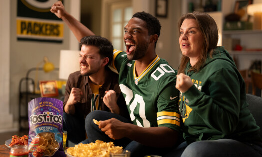NFL fans cheer for their favorite teams while eating a bag of Tostitos