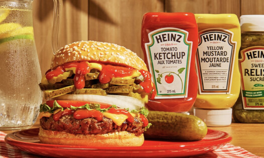 A hamburger with Heinz ketchup, mustard, and pickle relish