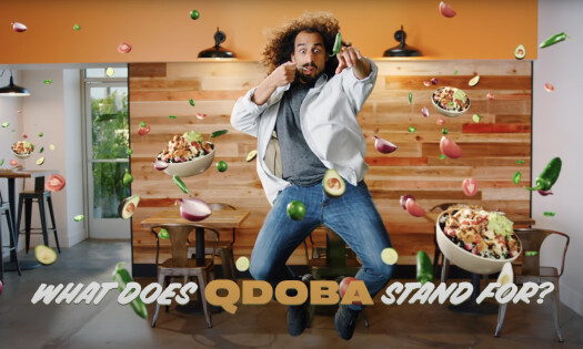 A man jumping with bowls and ingredients around him and the text below: What does QDOBA stand for?