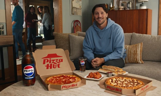 Josh Allen on a couch enjoying Pizza Hut