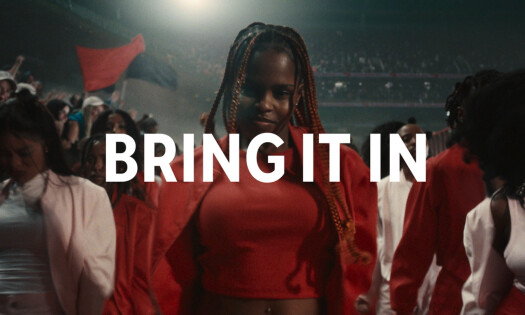 Dancers and a marching band stand in a crownd