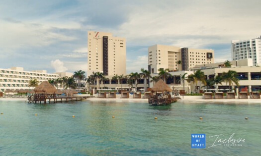 A top shot of a couple walking towards the water at a white-sand beach with text: Time here is worth more