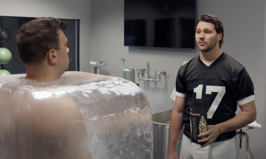 Josh Allen holding a Wonderful Pistachios snack bag faces a man frozen in ice