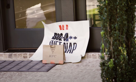 A man wipes his mouth using the table cloth