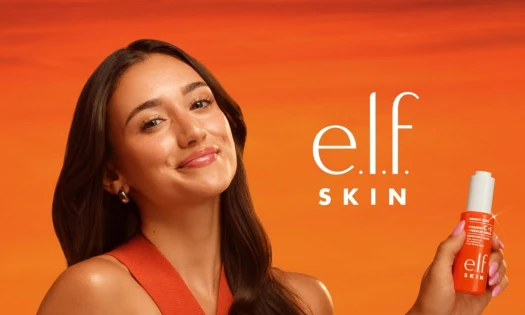 A woman holding up the new elf SKIN product