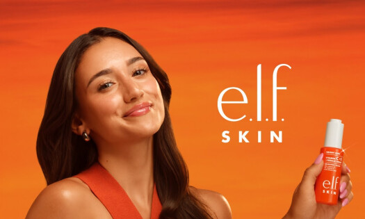 A woman holding up the new elf SKIN product