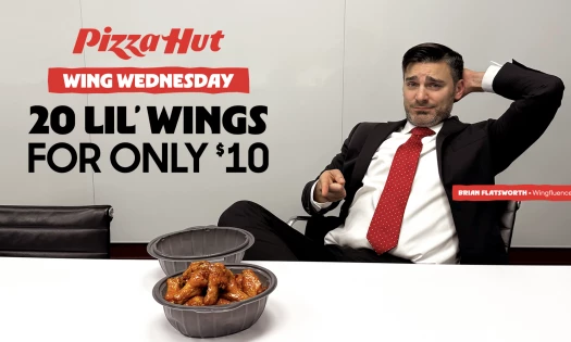Brian Flatsworth points at his Pizza Hut 'Lil Wings on his office desk
