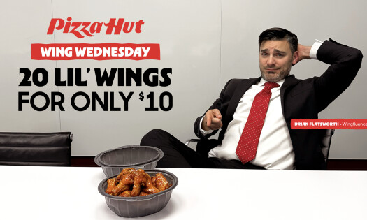 Brian Flatsworth points at his Pizza Hut 'Lil Wings on his office desk