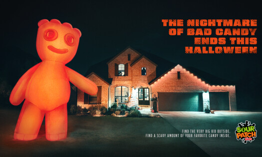 A giant inflatable Sour Patch Kid towers over a house
