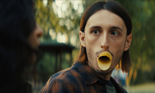 A man doing the 'duck lips' with two pieces of Pringles