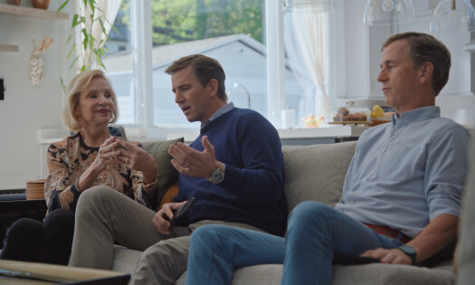 Eli Manning talking to an elderly family in the living room