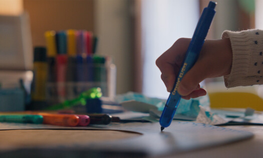 A young child drawing with Crayola