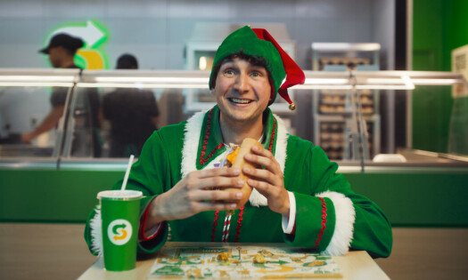 An elf eating Subway's sandwich