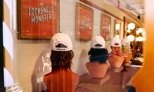 A photo of PNC Bank's activation, showing mannequin heads with "mullet, hockey-like" styled haircuts and baseball caps