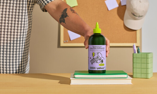 A person grabbing a bottle of graza and yahoo olive oil