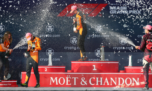 f1 racers podium throwing moet & chandon champagne