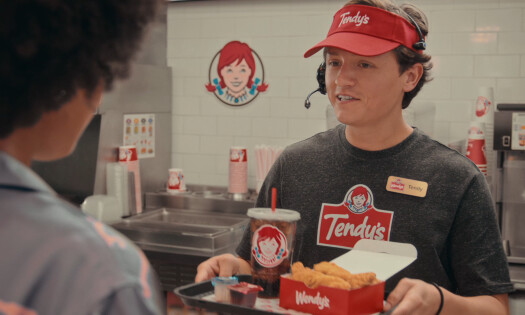 A Wendy's employee serving 'Tendy's' to a customer