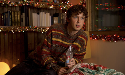 Troye Sivan with festive attire holding a bottle of Smirnoff ICE