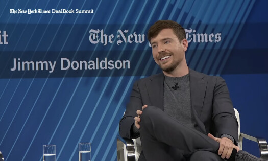 MrBeast, real name Jimmy Donaldson, sitting in a chair on a stage at The New York Times' DealBook Summit