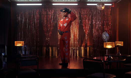 A cowboy stands in the middle of a stage