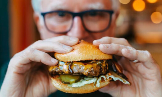 man grabbing a burger towards the camera