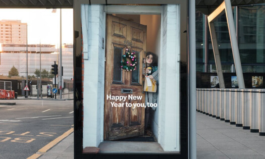 An out-of-home advertisement showing a hungover girl accepting a McDelivery order at a front door