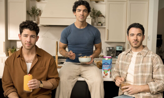 The Jonas Brothers by a kitchen counter